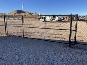 This is an example of a large motorized electric security gate in a black chain link install done in Hurricane Utah